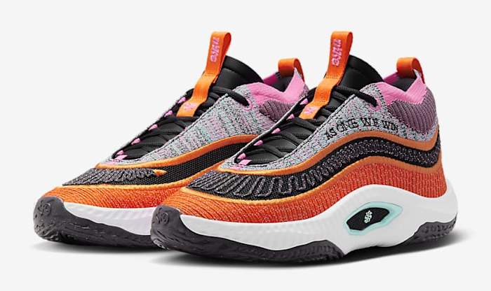 Side view of orange and black Nike shoes.